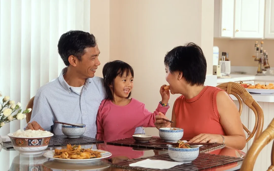 A family around a dinner table, one person calmly setting a boundary during conversation
