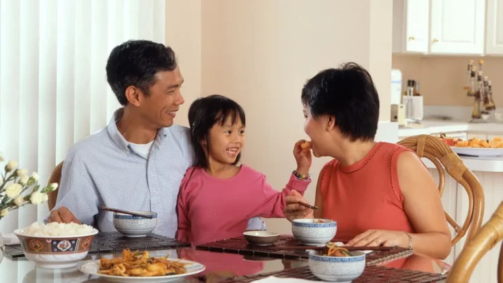 A family around a dinner table, one person calmly setting a boundary during conversation