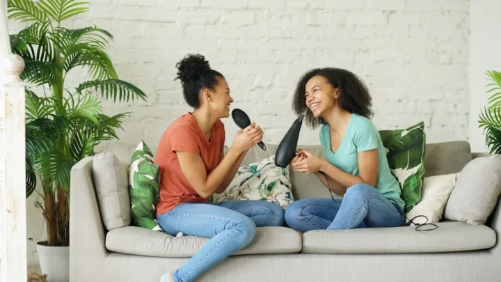 Two friends on a sofa having a calm, honest conversation about a boundary