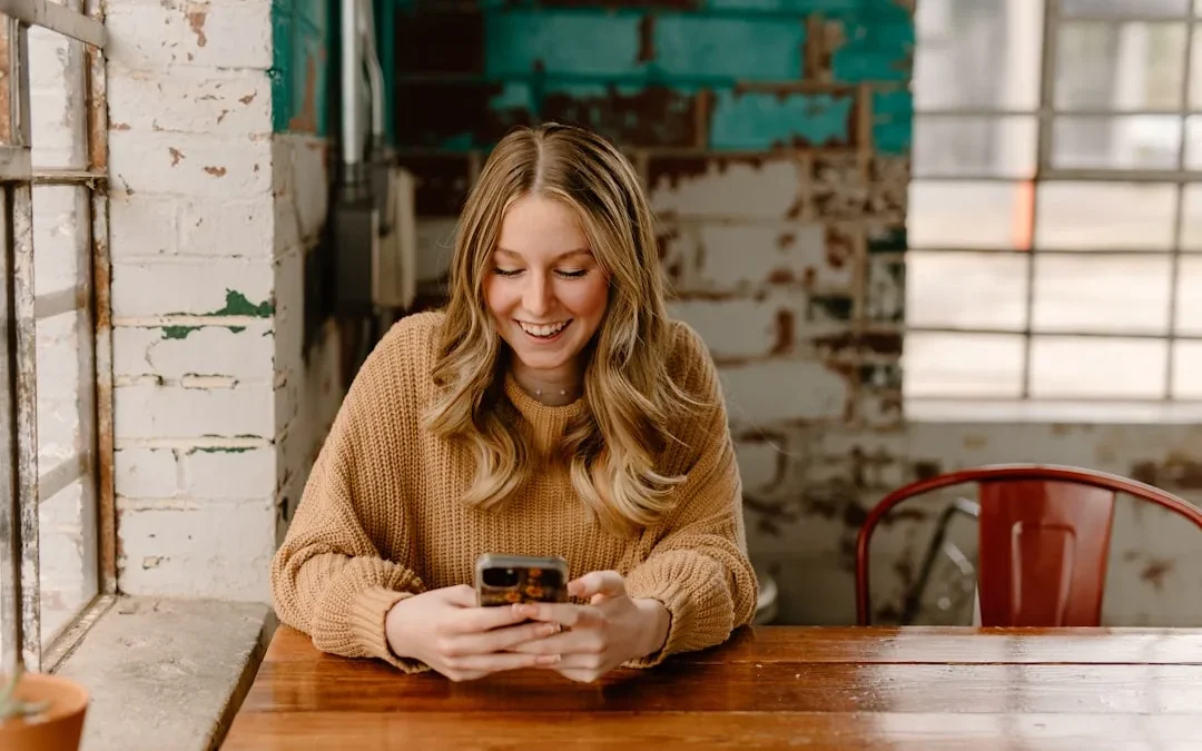 A person smiling while sending a flirty reply to a text on their phone