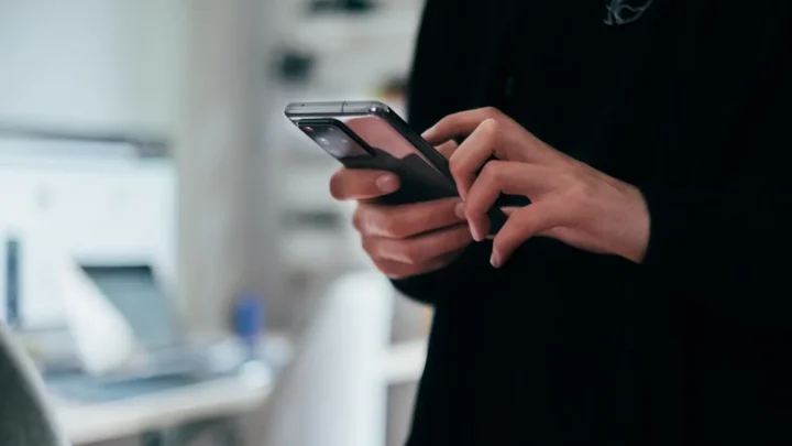 A person cautiously reading a message from an unknown number on their phone