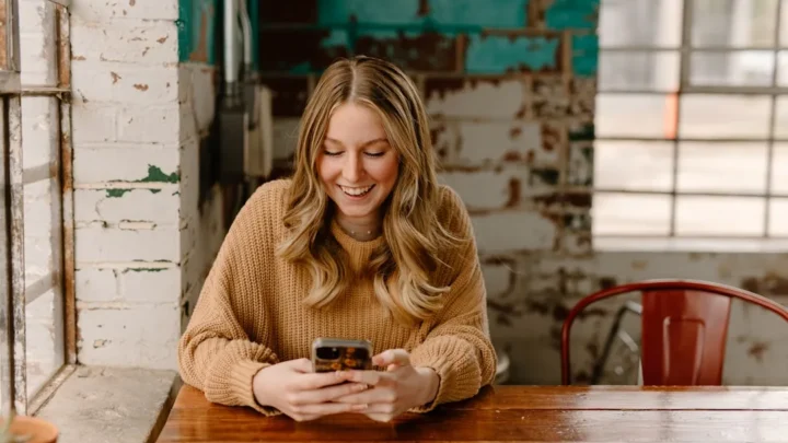 Woman looking at her phone while waiting for a response to her text message