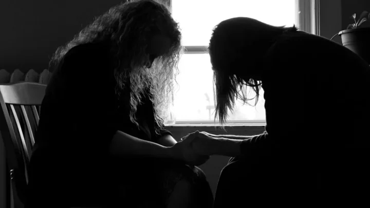 supportive friend sitting beside grieving person in gentle daylight