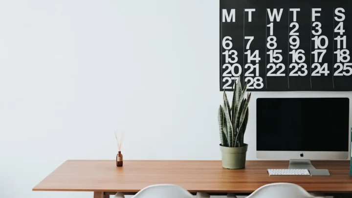 silver iMac on brown wooden desk