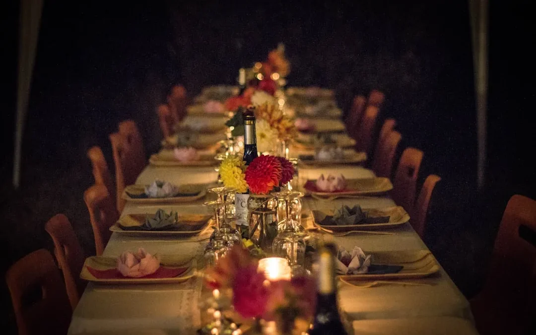 A long dining table set for a dinner party with flowers and candles