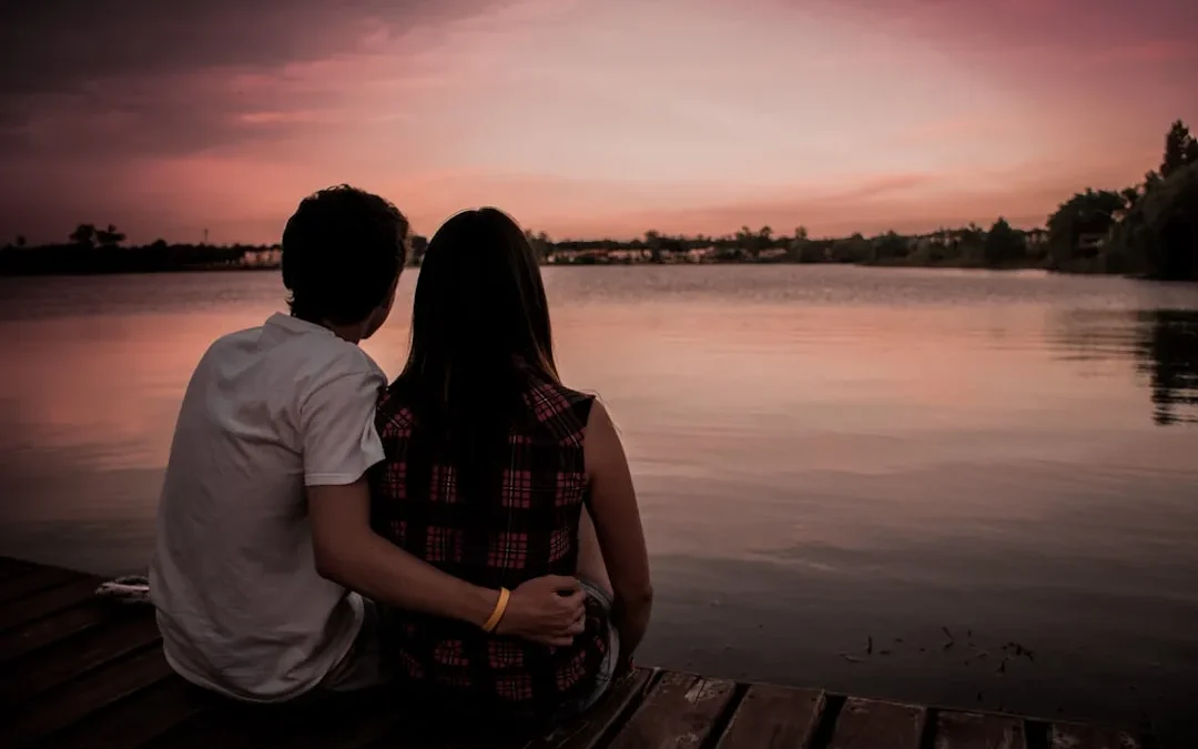 man and woman sitting on dock