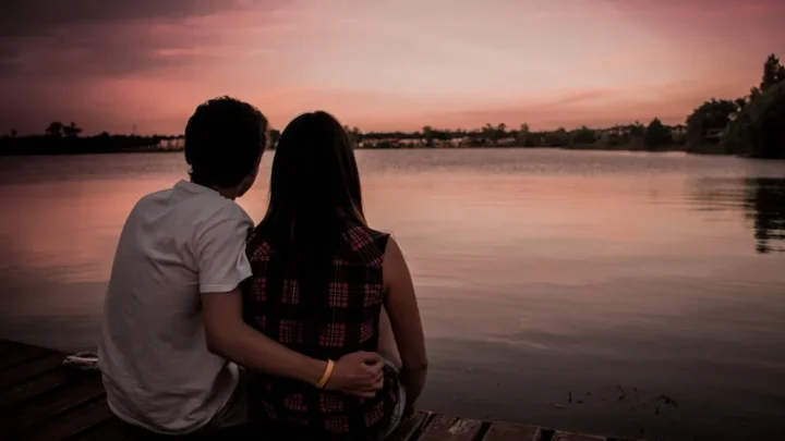 man and woman sitting on dock