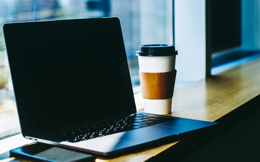 black laptop computer on brown wooden table