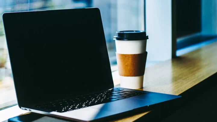 black laptop computer on brown wooden table