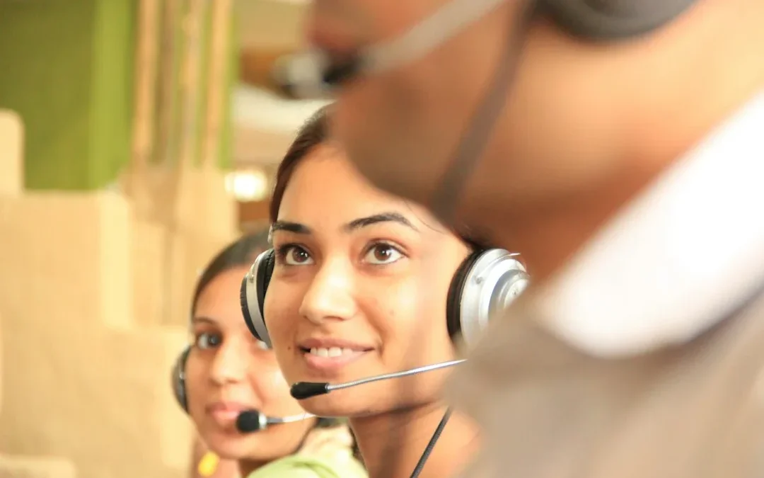 Two women wearing headsets in a bright office workspace