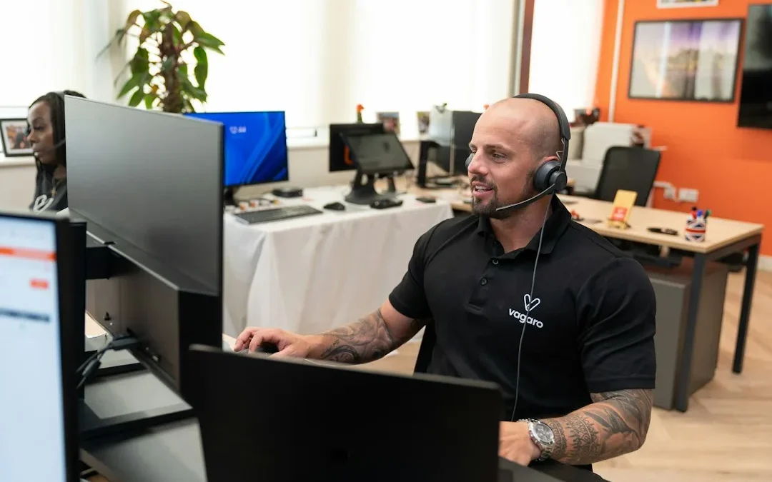 a man wearing a headset sitting in front of a computer